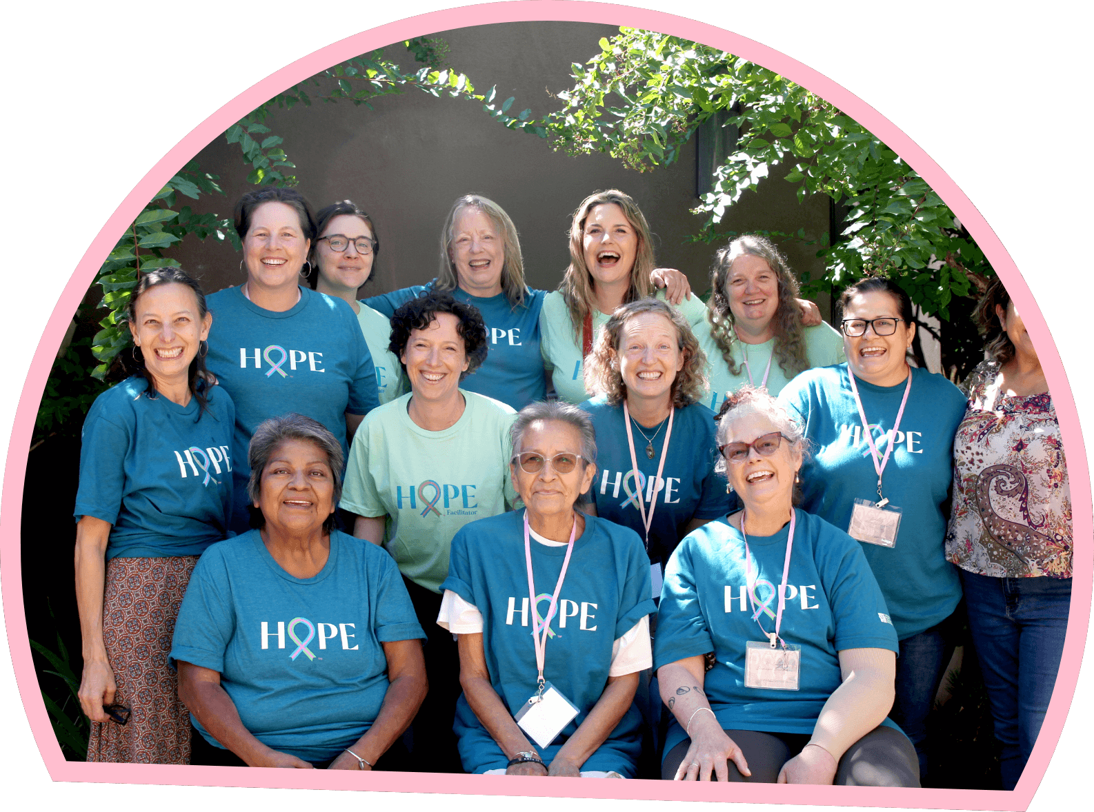 Group of breast cancer survivors and supporters wearing Hope shirts and smiling together outdoors