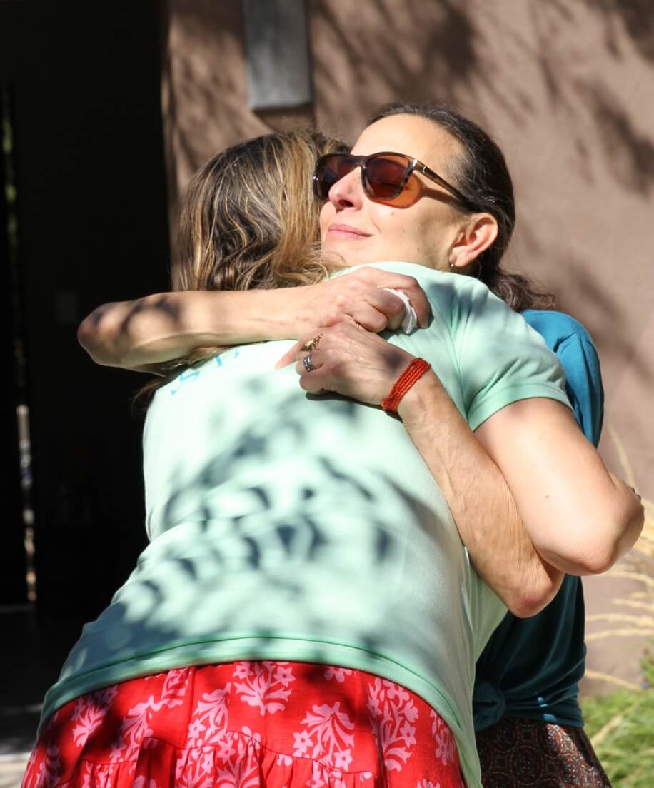 Two women embracing in a moment of support outdoors
